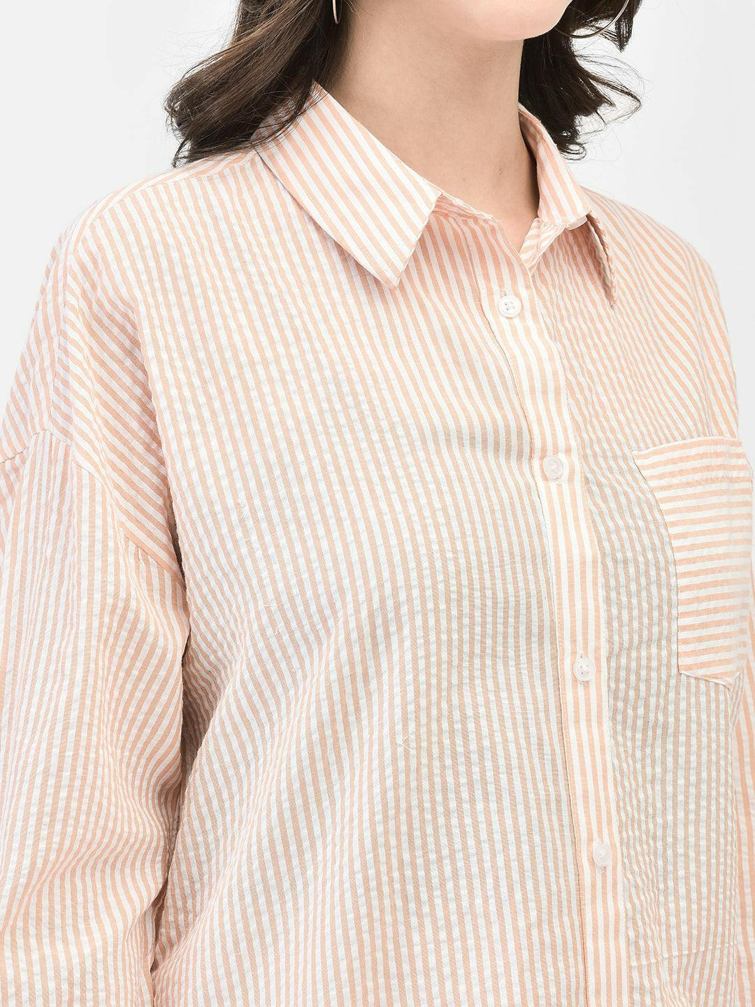 Alt Text: Model wearing elvtd. peach striped button-up shirt with white pants. mage Description: "A model wearing an elvtd. peach striped button-up shirt paired with white pants. The stylish and casual outfit is perfect for warm weather and various occasions.