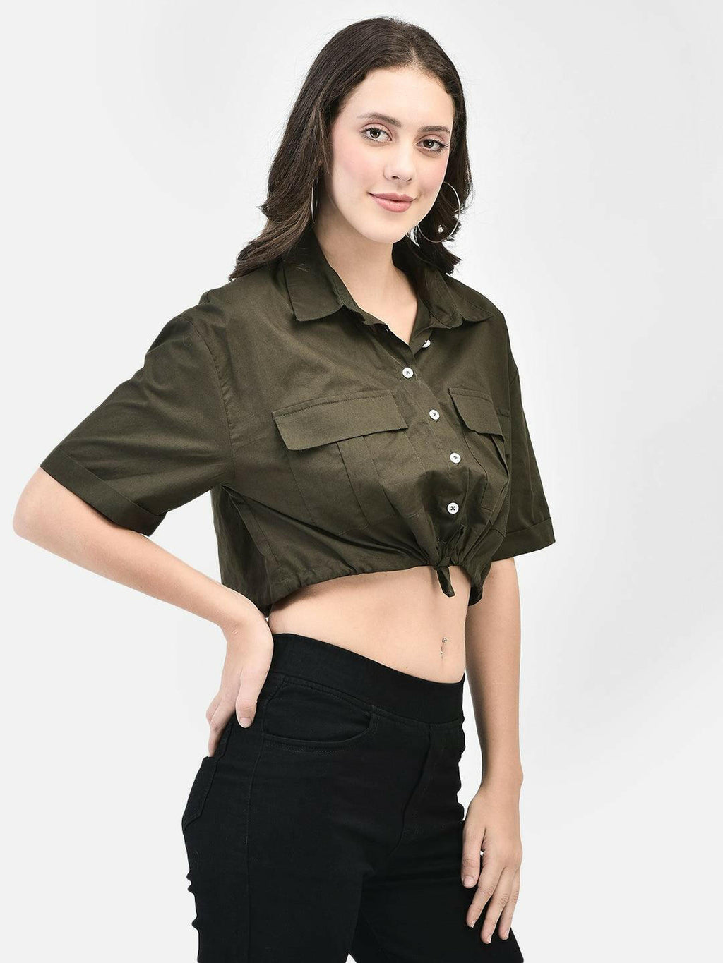 Model styling the olive shirt with black pants, showing button details