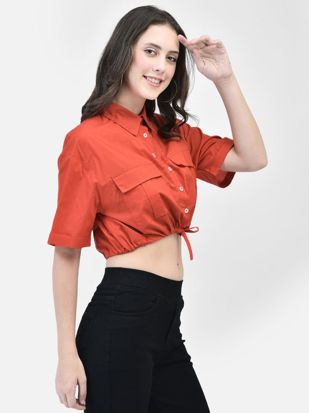 Woman styling crimson midriff shirt with relaxed stance – summer look