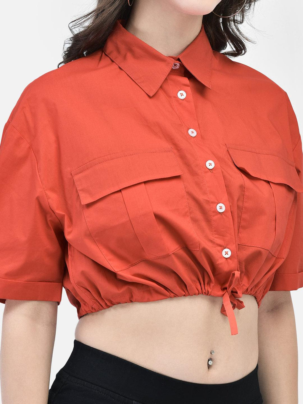 Close-up of red cropped cotton shirt with button-down design and drawstring hem