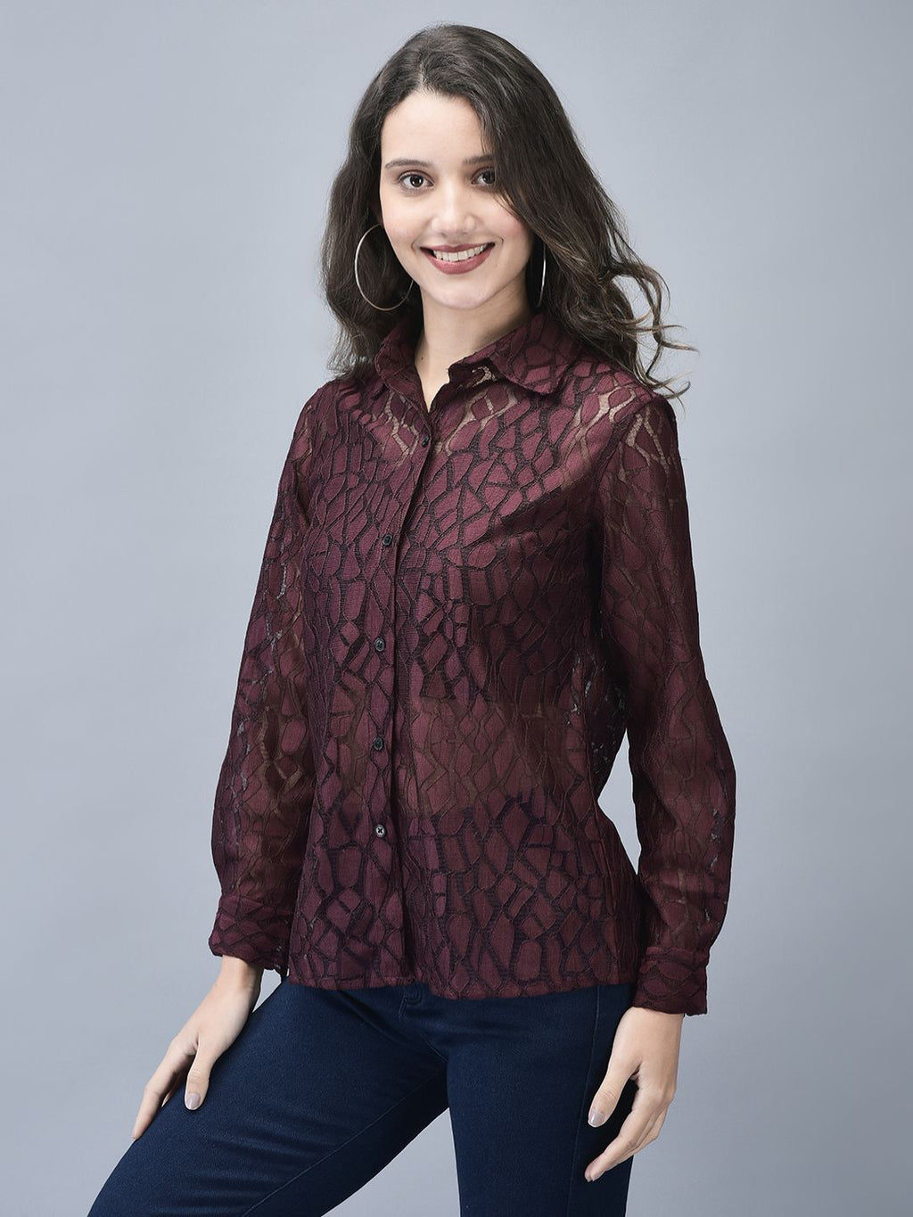 Woman in wine textured shirt standing with one hand on her hip, front angled view